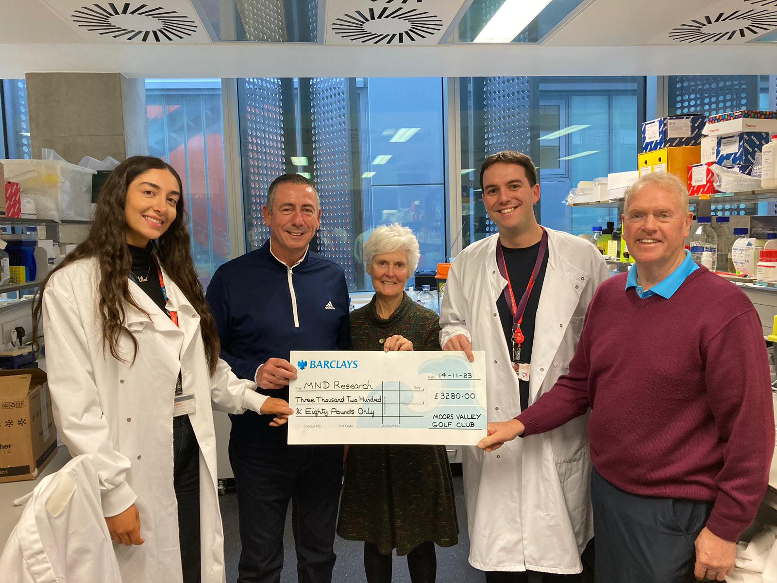 Visitors from Moores Valley Golf Club presenting a fundraising cheque in the White Lab